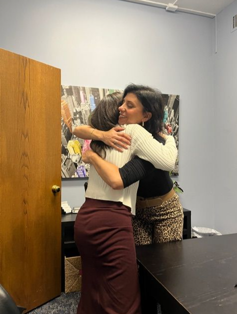 Carla Torres at the closing table in Hoboken hugging happy client